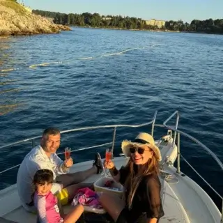 Guests toasting with champagne aboard a dolphin tour in Rovinj at sunset, enjoying the stunning coastal scenery and marine life encounters.