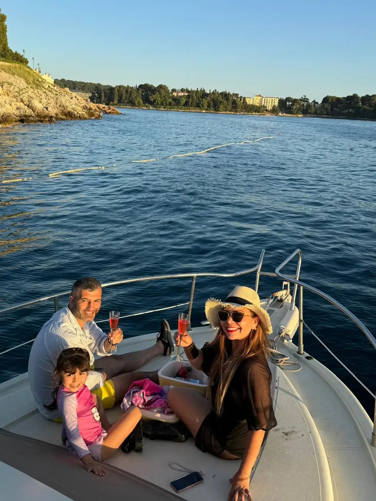 Guests toasting with champagne aboard a dolphin tour in Rovinj at sunset, enjoying the stunning coastal scenery and marine life encounters.