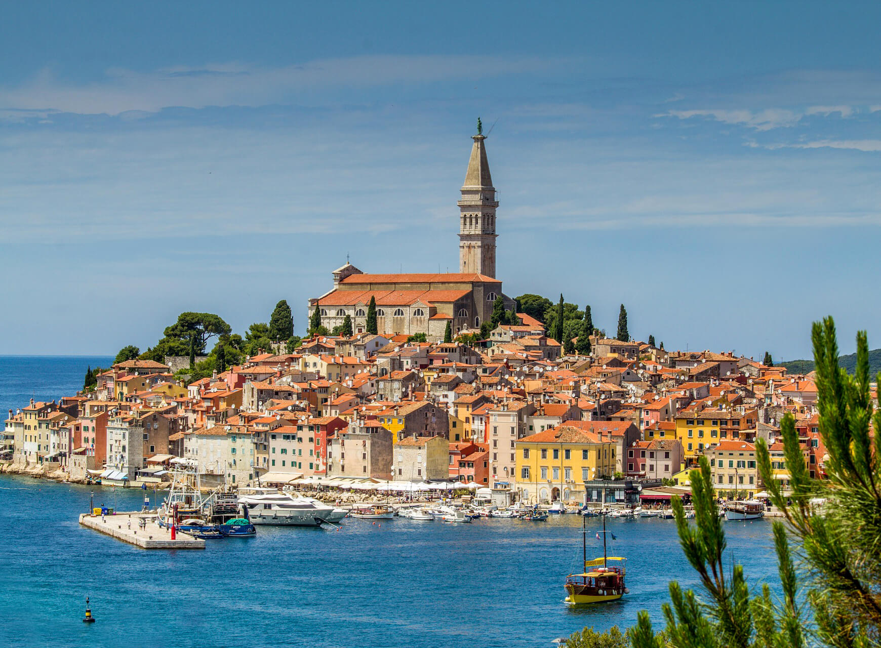 Stunning view of old town Rovinj with the Church of St. Euphemia towering over colorful buildings and the Adriatic Sea.